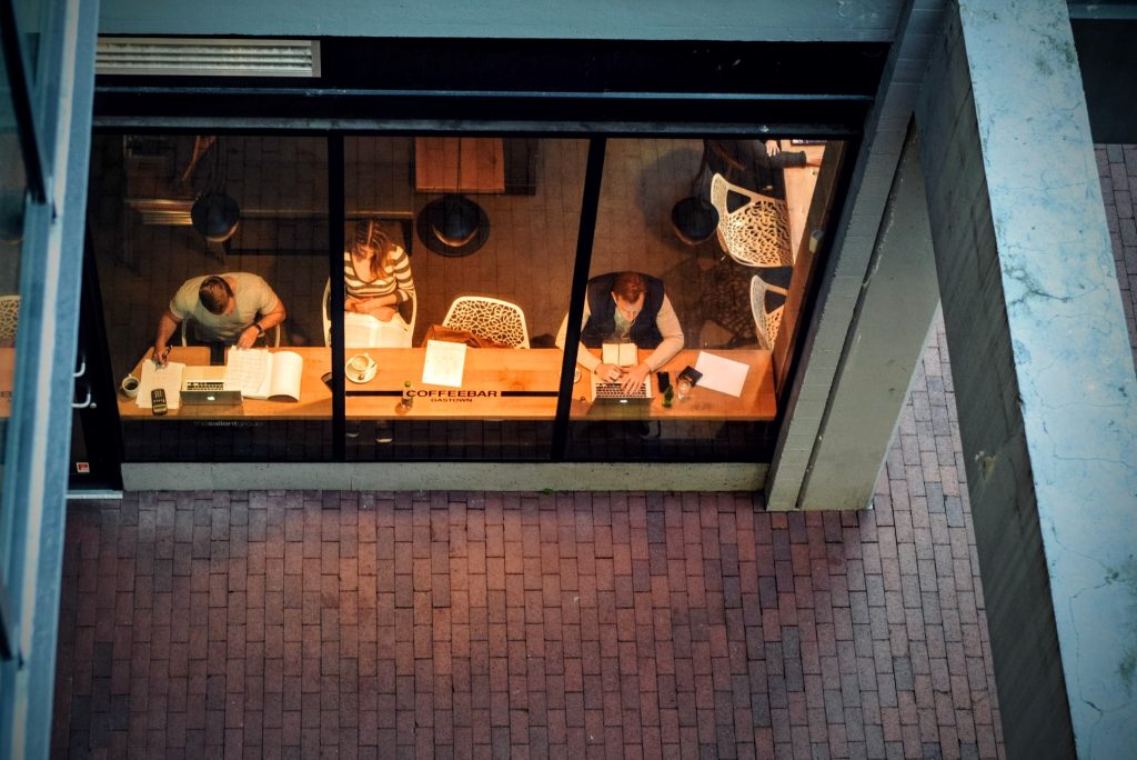 Three people through a coffee shop window.